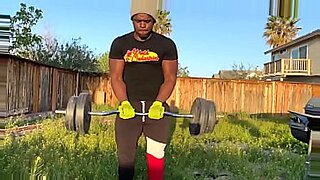 A buff guy works out alone at the gym, showcasing impressive bicep exercises.