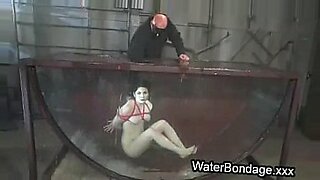 Brunette in rope bondage dive in water